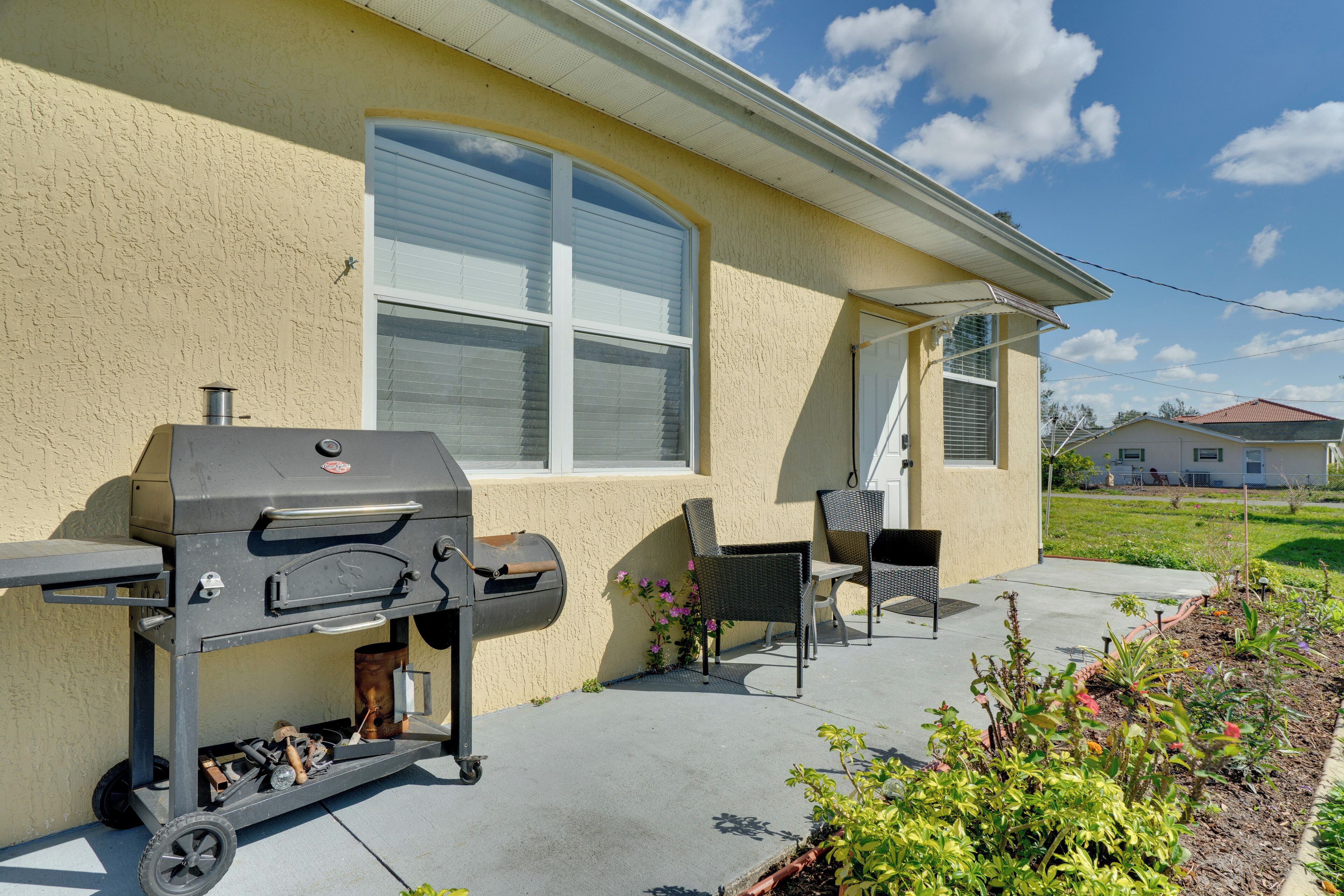 Une maison dotée d’un patio, d’un barbecue et de mobilier d’extérieur.