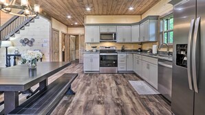 A modern kitchen with wooden flooring, stainless steel appliances, and a central island.