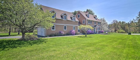 A two-story building with a brown exterior and a green lawn in front.
