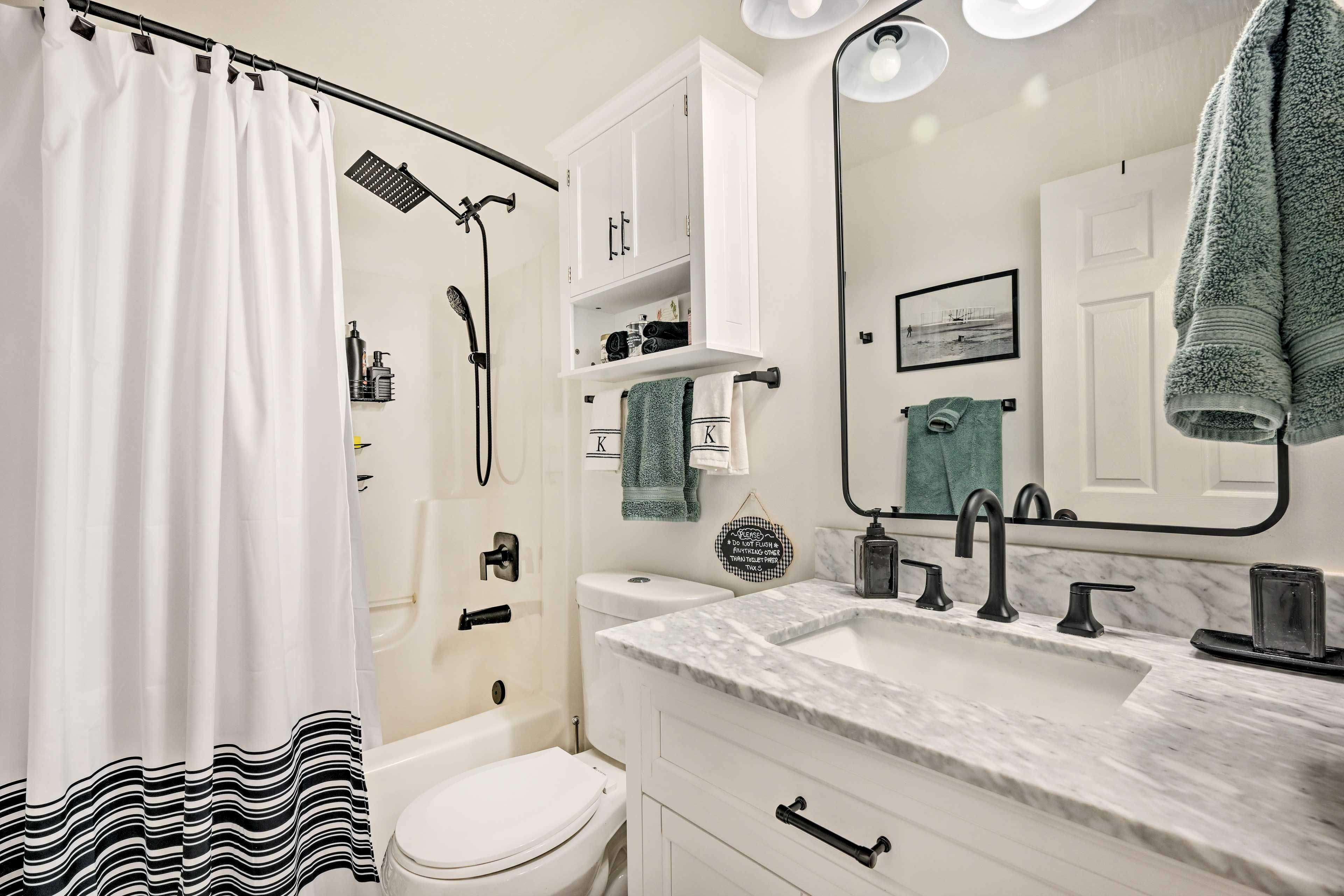 A modern bathroom with a shower, toilet, and sink.