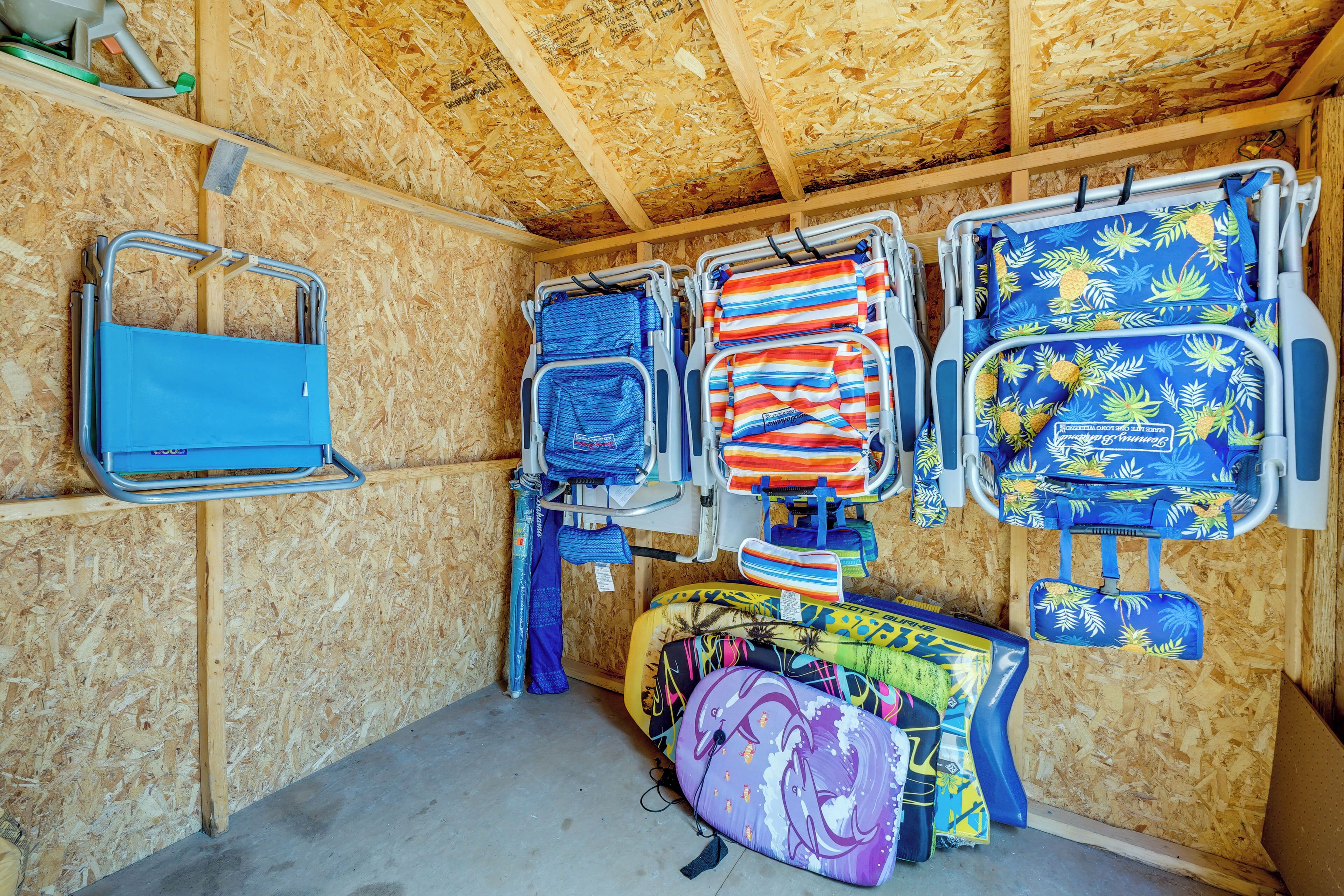 Ein Zimmer mit Holzboden und -wänden, das mehrere farbenfrohe Gepäckstücke und einen blauen Stuhl beherbergt.