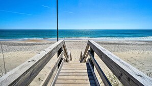 A wooden boardwalk leading to a beach with a clear blue sky. - Modern Surf City Beach House w/ Hot Tub! (Holly Ridge)