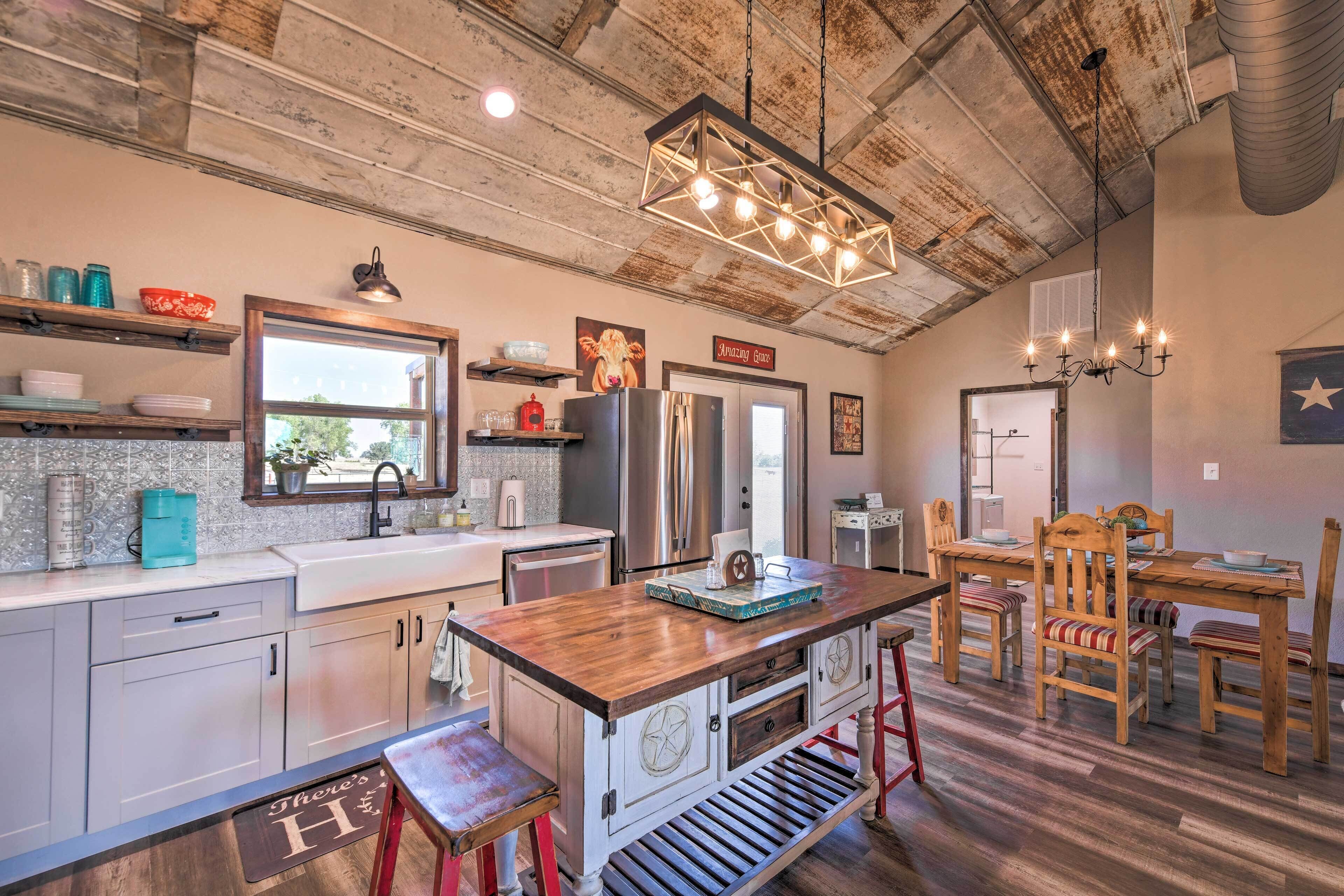 A rustic kitchen with a wooden island, stainless steel appliances, and a farmhouse-style dining area.