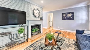 A living room with a fireplace, a television, and a world map on the wall.