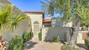 A building with a stone facade, a tiled roof, and a paved pathway leading to a gated entrance. - Dog-friendly Scottsdale Retreat w/ Private Pool! (Scottsdale)
