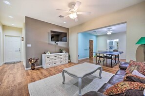 A spacious living room with a white coffee table, a brown leather sofa, and a dining table with chairs. - Walk to Lake: Townhome w/ Hot Tub in Afton! (Afton)