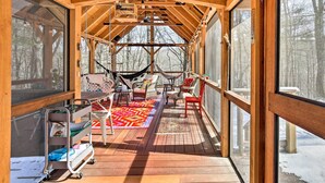 A wooden deck with a hammock, chairs, and a cart with bags. - West Cornwall Cabin ~ 4 Mi to Covered Bridge! (West Cornwall)