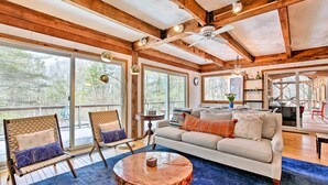 A spacious living area with a large window, a wooden ceiling, and a round coffee table. - West Cornwall Cabin ~ 4 Mi to Covered Bridge! (West Cornwall)