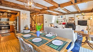 A spacious kitchen with modern appliances, a dining area with a wooden table set for four, and a cozy living room with a fireplace. - West Cornwall Cabin ~ 4 Mi to Covered Bridge! (West Cornwall)