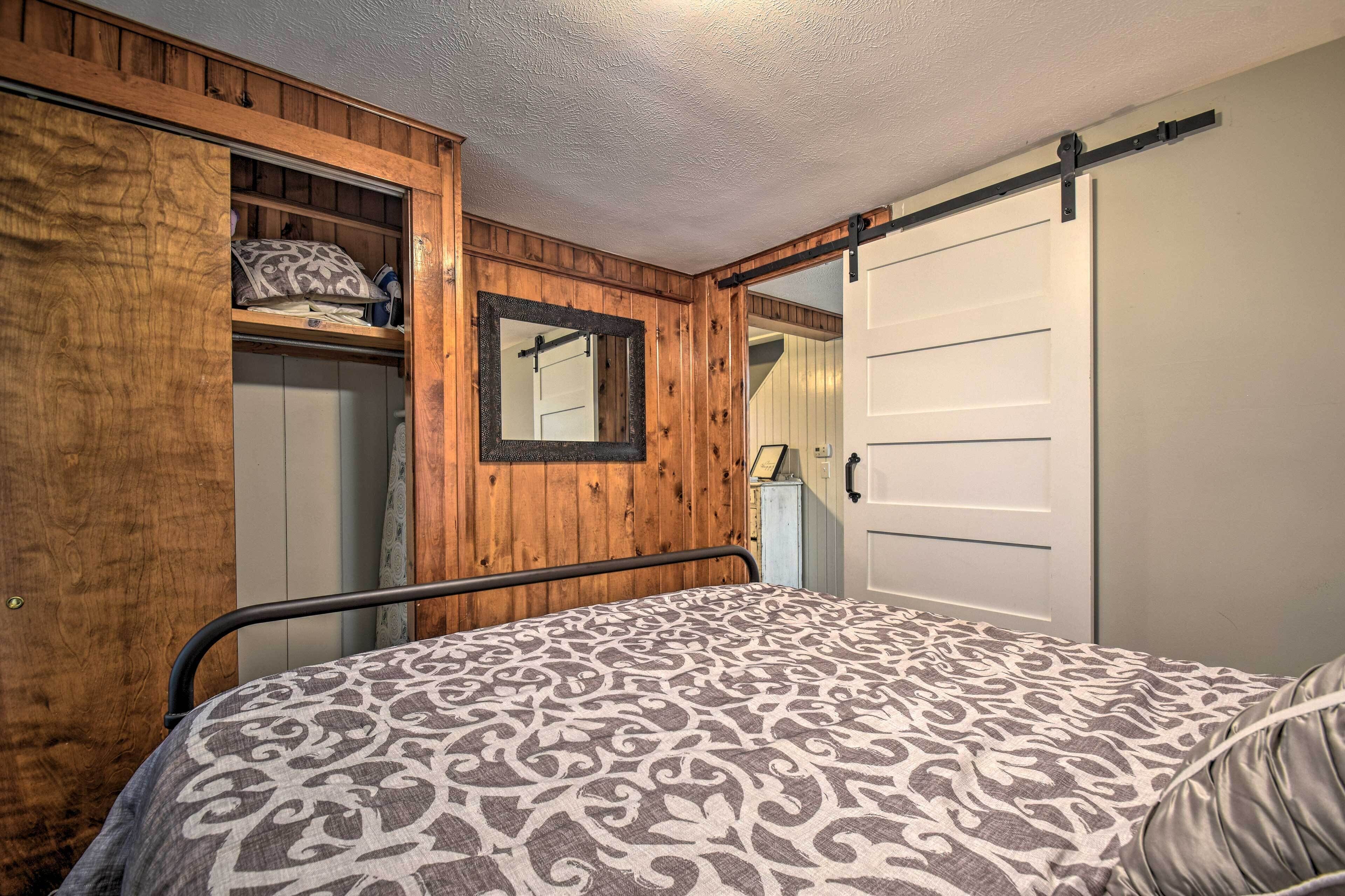 Un dormitorio con cama, armario de madera y puerta corrediza.