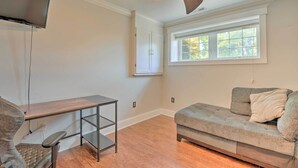A room with a ceiling fan, a TV, a sofa, a desk, and a window. - Pet-friendly Mechanicsville Retreat w/ Deck! (Mechanicsville)