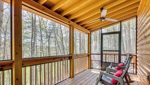A wooden deck with rocking chairs and a view of a forest. - Stunning Murphy Cabin - 5 Mi to Cherokee Lake! (Murphy)
