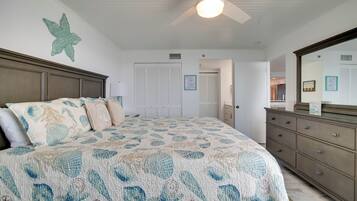 A bedroom with a bed, dresser, and a ceiling fan.
