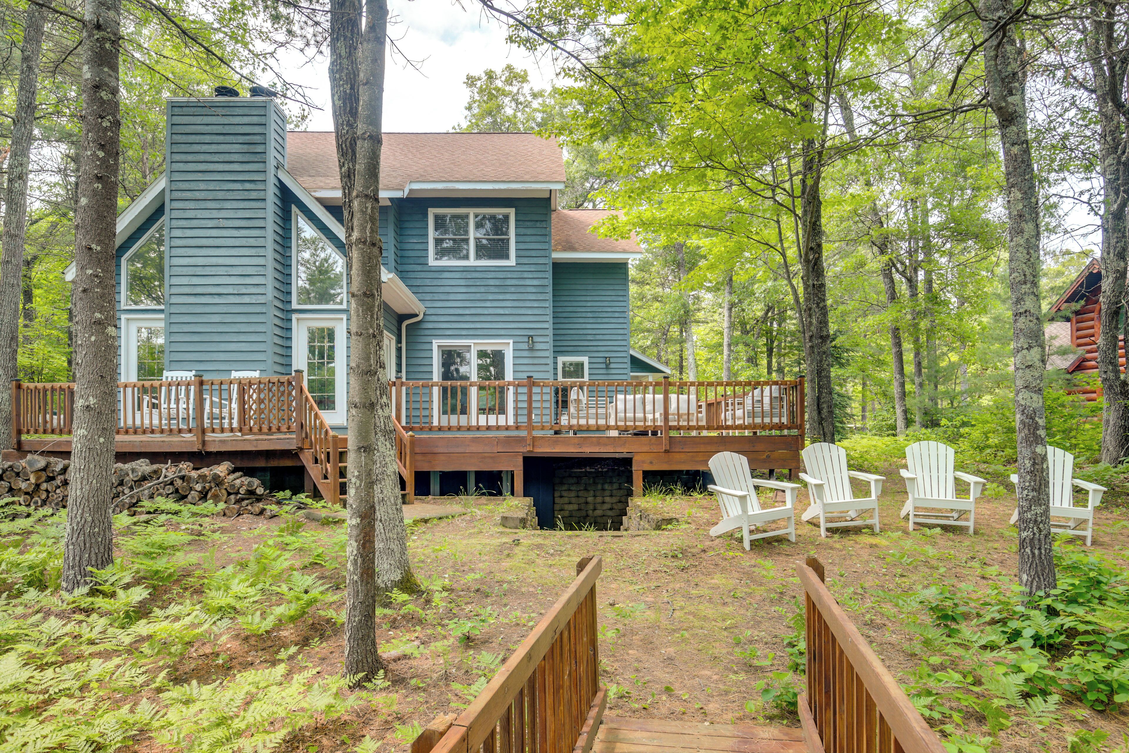 A two-story cabin with a deck and outdoor seating area.