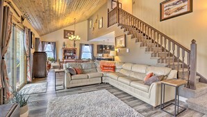 A spacious living room with a large sectional sofa, a wooden coffee table, and a staircase leading to an upper level. - Private Sauna & Mtn Views: Idaho Springs Gem (Idaho Springs)