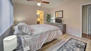 A bedroom with a bed, a nightstand, a lamp, a ceiling fan, a dresser, a mirror, and a rug. - Pet-friendly Prescott Townhome w/ Fireplace! (Prescott)