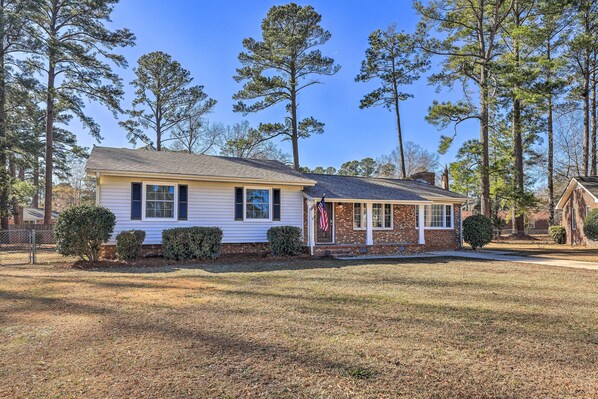 A single-story house with a front porch, a brick section, and a small front yard. - Family-friendly New Bern Home w/ Backyard! (New Bern)