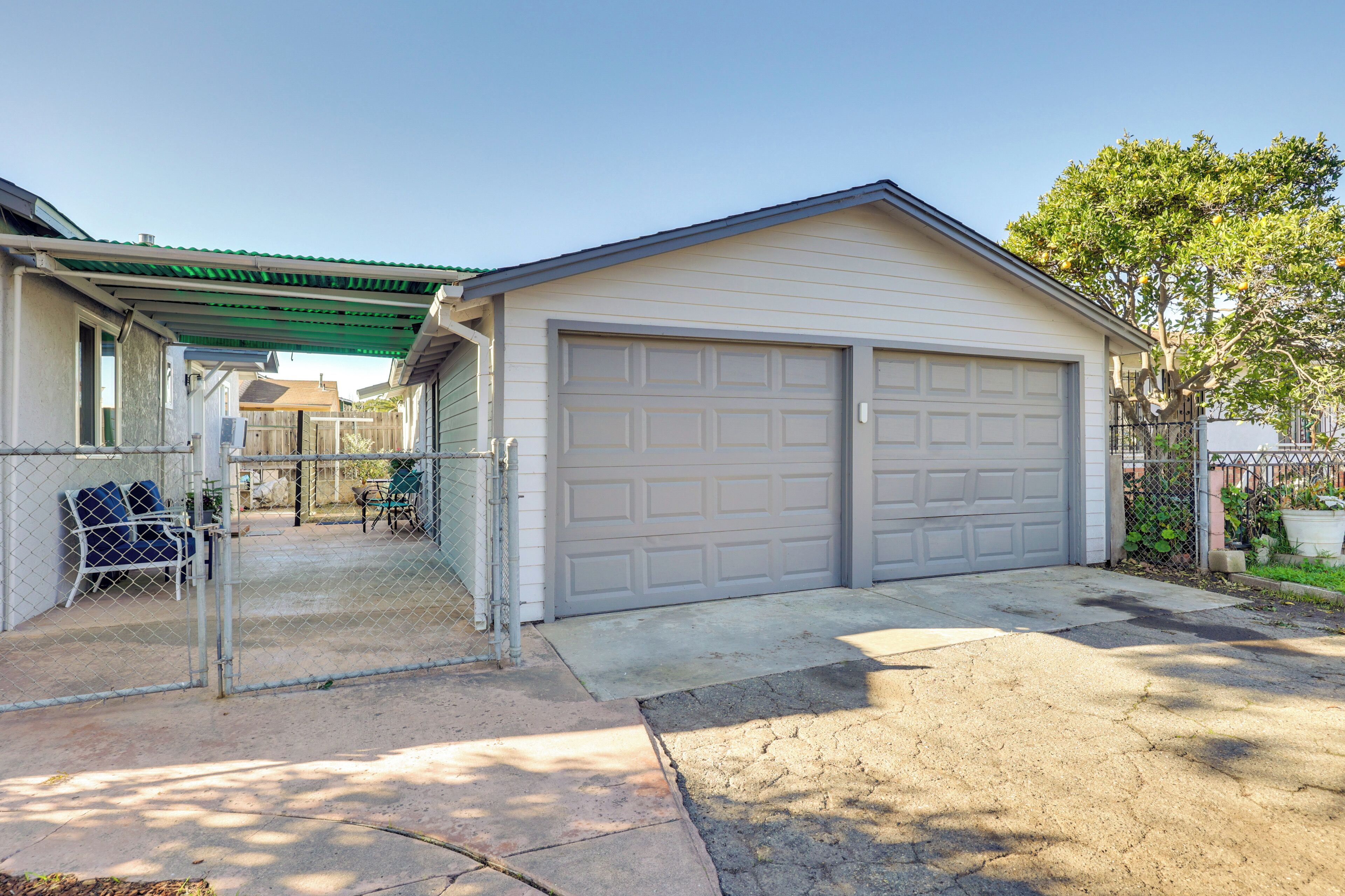 Eine Garage mit Wohnhof und einem eingezäunten Garten.