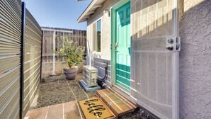 A small, enclosed outdoor area with a green door, a potted plant, and a doormat. - Quiet Carpinteria Cottage By Town & Beaches (Carpinteria)
