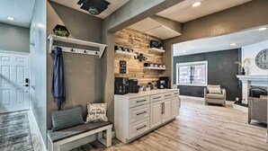 A modern kitchen with wooden accents, a built-in coffee station, and a cozy seating area with a bench and cushions. - Luxurious & Forested Oasis in Flagstaff w/ Hot Tub (Flagstaff)