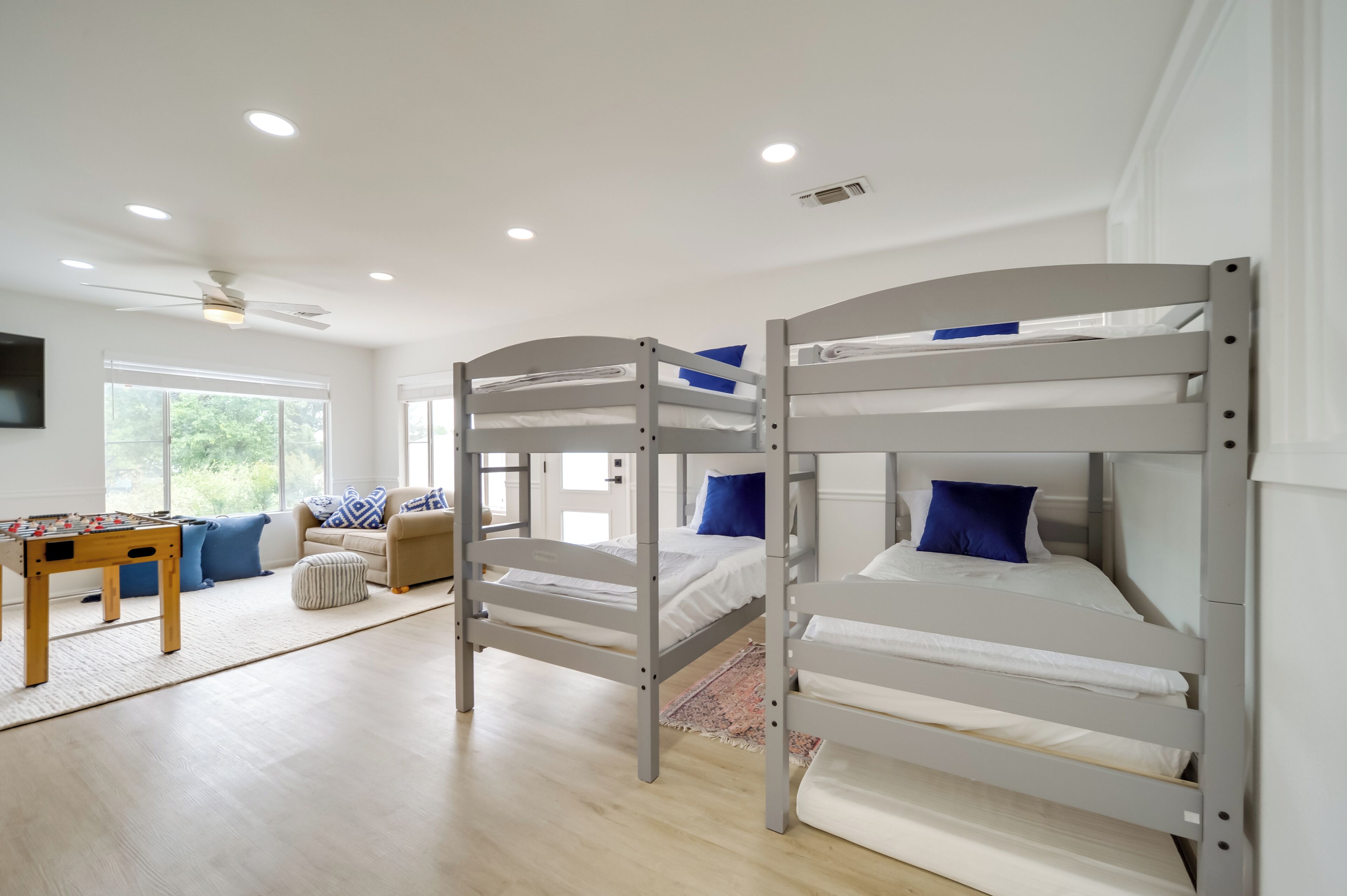 A room with bunk beds, a sofa, a coffee table, and a TV.