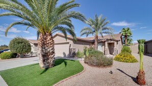 A residential area with palm trees, a well-maintained lawn, and a gravel driveway. - Maricopa Retreat w/ Peaceful Backyard Oasis! (Maricopa)