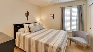 A bedroom with a bed, a chair, a ceiling fan, a window with curtains, and a cactus decoration on the wall. - Maricopa Retreat w/ Peaceful Backyard Oasis! (Maricopa)