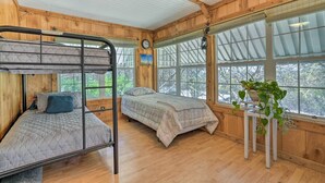 A cabin with two bunk beds, a wooden interior, and large windows. - Charming Ingram Home w/ Yard & Furnished Patio! (Ingram)