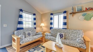 A living room with two sofas, a coffee table, and a lamp. - Sun, Sand & Smiles! Ocean Isle Apt w/ Balcony (Ocean Isle Beach)