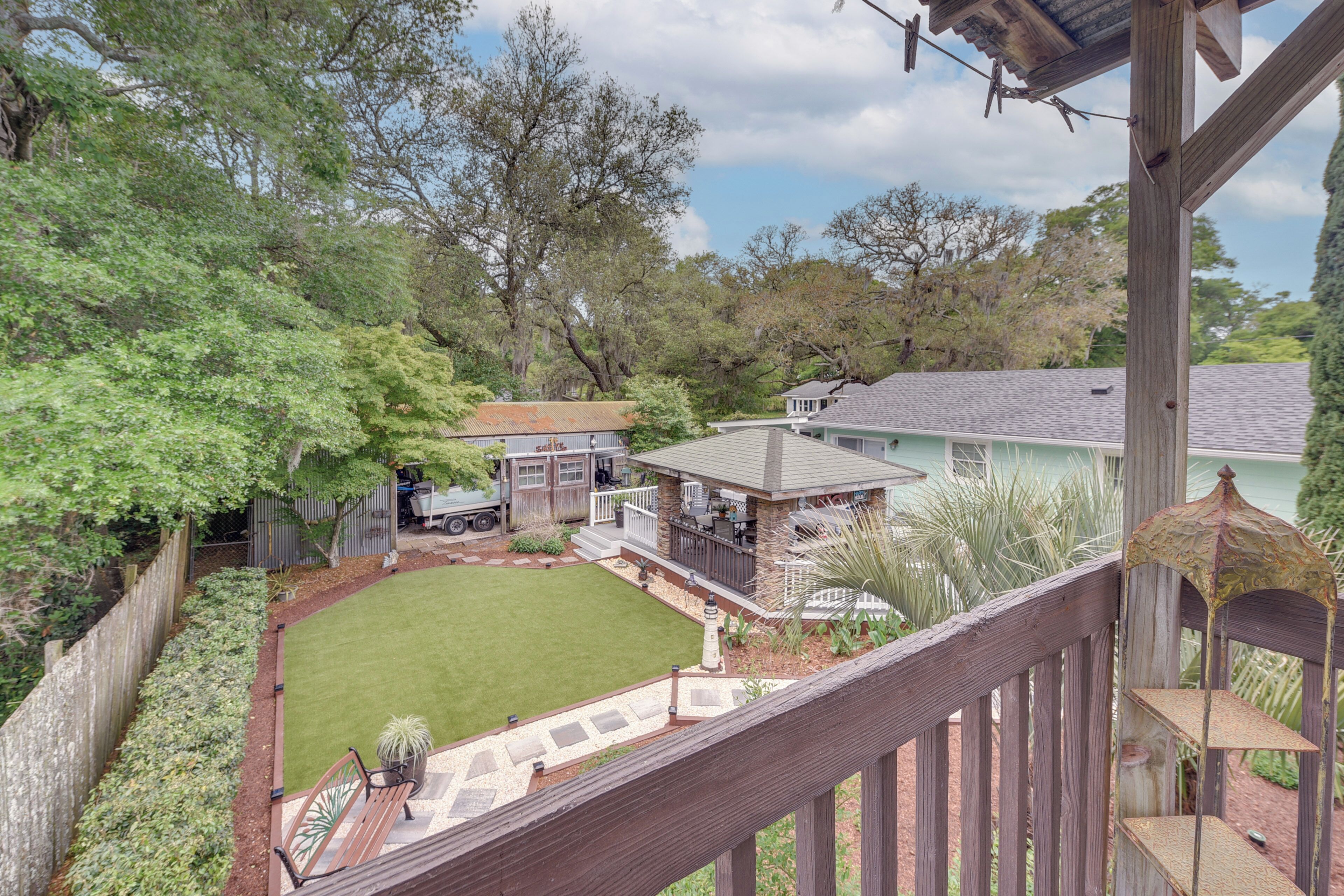A backyard with a lawn, a patio, and a wooden fence.
