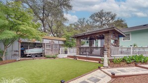 A residential property with a well-maintained lawn, a stone patio, and a fenced backyard. - Sun, Sand & Smiles! Ocean Isle Apt w/ Balcony (Ocean Isle Beach)