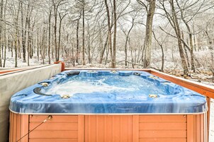 A hot tub in a snowy forest setting.