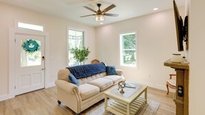 A living room with a beige sofa, a coffee table, a ceiling fan, and a fireplace. - Historic Madison Retreat - 1 Mi to Ohio River (Madison)
