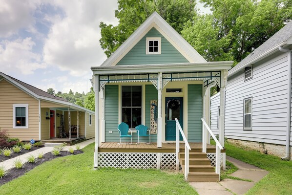 A two-story house with a porch, a small staircase, and a front door.