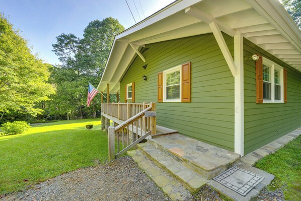 A green house with a porch, a flag, and a well-kept lawn. - Fun Pet-friendly Highlands Retreat w/ Fenced Yard! (Highlands)