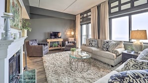 Una sala de estar moderna con chimenea, un sofá, una mesa de centro y una televisión.