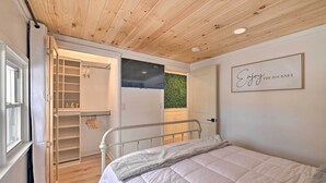 Ein Schlafzimmer mit Bett, Kleiderschrank und einer Wand mit einem motivierenden Zitat.