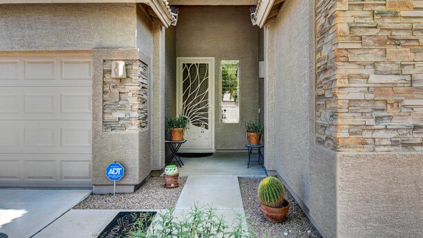 A house with a garage, a stone exterior, a decorative door, and potted plants. - Avondale Getaway < 8 Mi to Estrella Mountain! (Avondale)