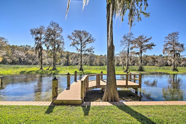 Escape to a serene waterfront retreat surrounded by lush greenery and mature trees.