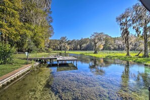 Enjoy a serene riverside retreat with a dock and lush surroundings.