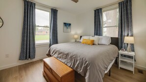 A bedroom with a bed, nightstands, a wooden bench, and a ceiling fan. - Modern Family Home in Mason w/ Backyard + Fire Pit (Mason)