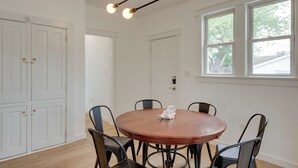 A dining area with a round wooden table, six chairs, and pendant lighting. - Modern Family Home in Mason w/ Backyard + Fire Pit (Mason)