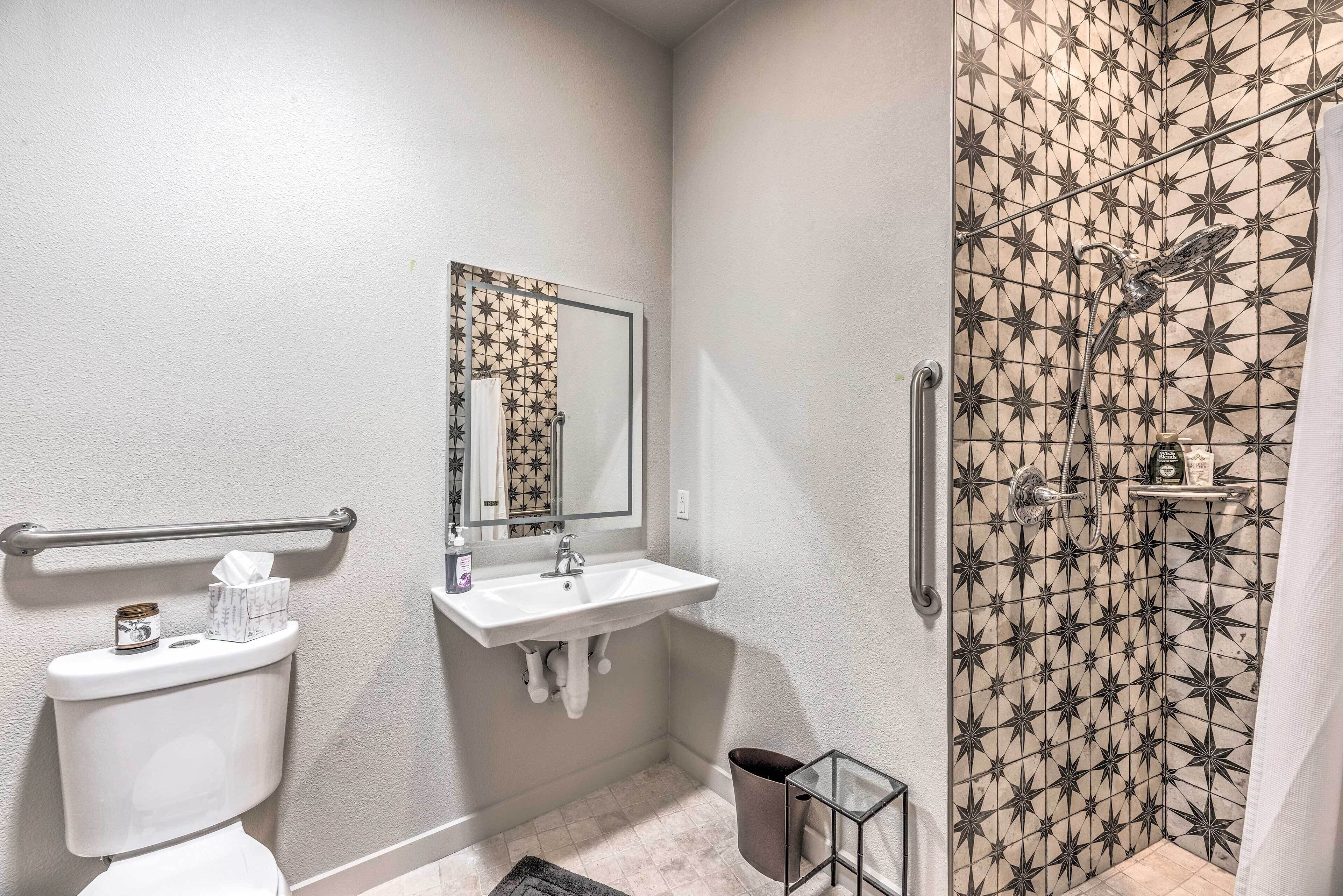 Ein Badezimmer mit Toilette, Waschbecken, Spiegel und Dusche mit Fliesen in Sternenmuster.
