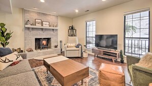 Una sala de estar amplia con chimenea, un televisor grande y asientos cómodos.