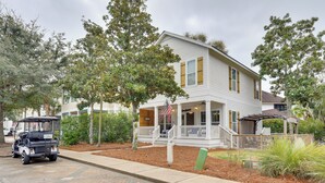 A two-story house with a porch and a flag. - Sunny Santa Rosa Beach in 30 A Neighborhood! (Santa Rosa Beach)