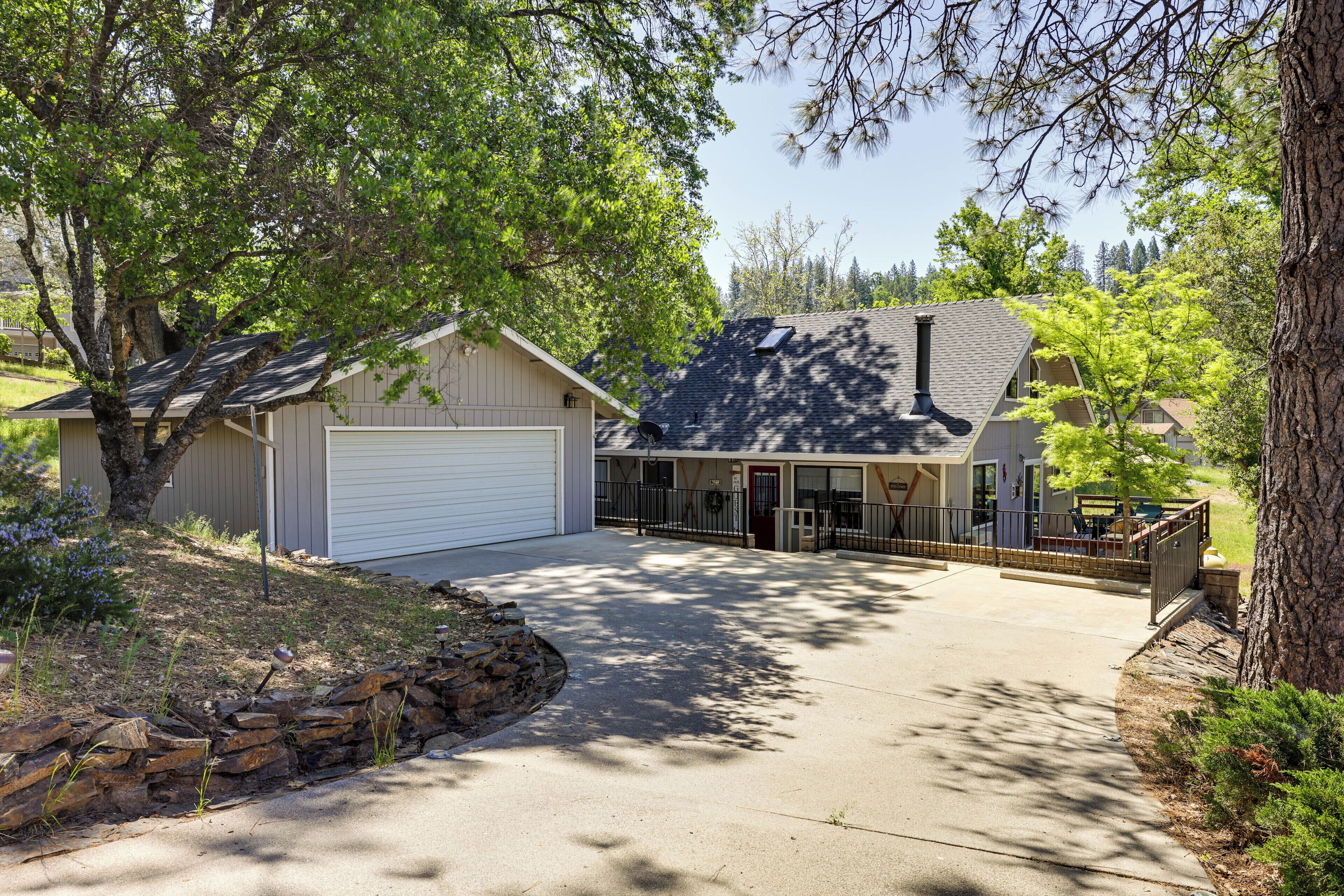 A residential property with a garage, a covered patio, and a stone retaining wall.