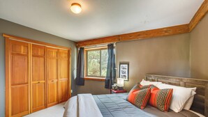Ein Schlafzimmer mit einem großen Bett, einem Holzschrank und einem Fenster mit Vorhängen.