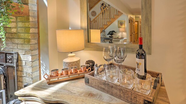 A wooden tray with wine glasses and a bottle, a fireplace, and a mirror reflecting a staircase. - Secluded Leesburg Retreat w/ Private Hot Tub! (Leesburg)