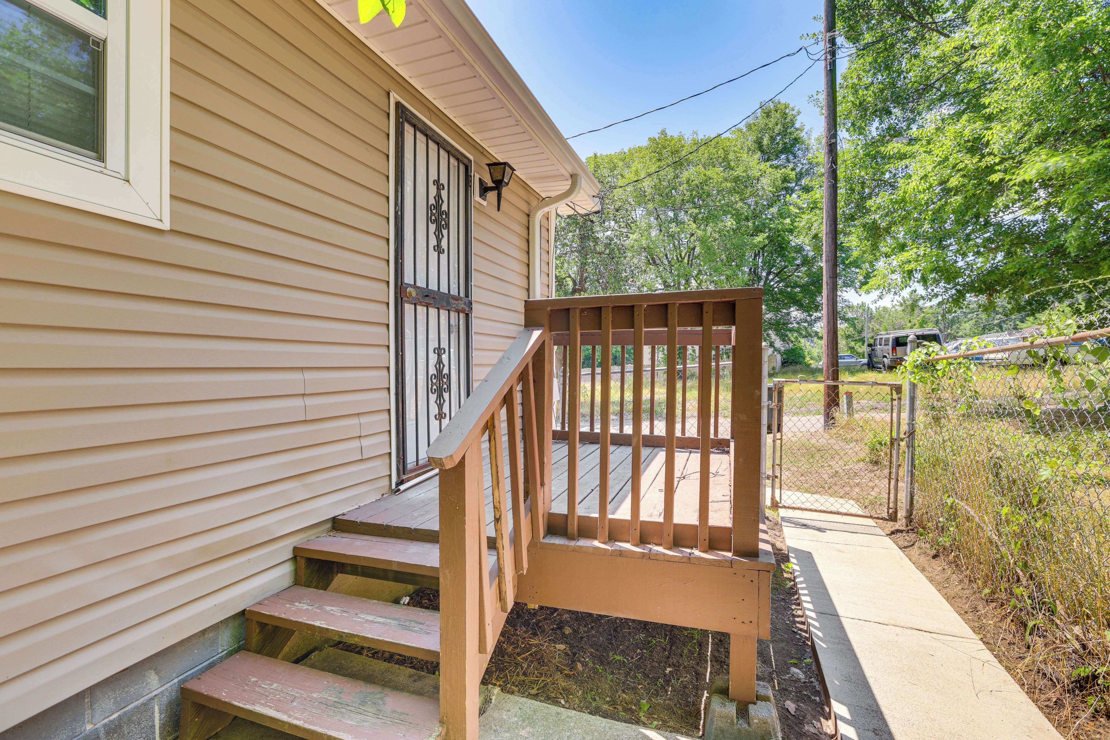 A wooden staircase leading to a porch with a railing.