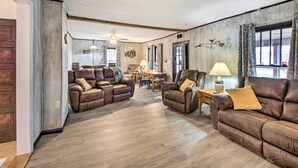 A spacious living room with leather sofas, a dining table, and a ceiling fan. - Illinois Vacation Rental Home: Pets Welcome (Palestine)